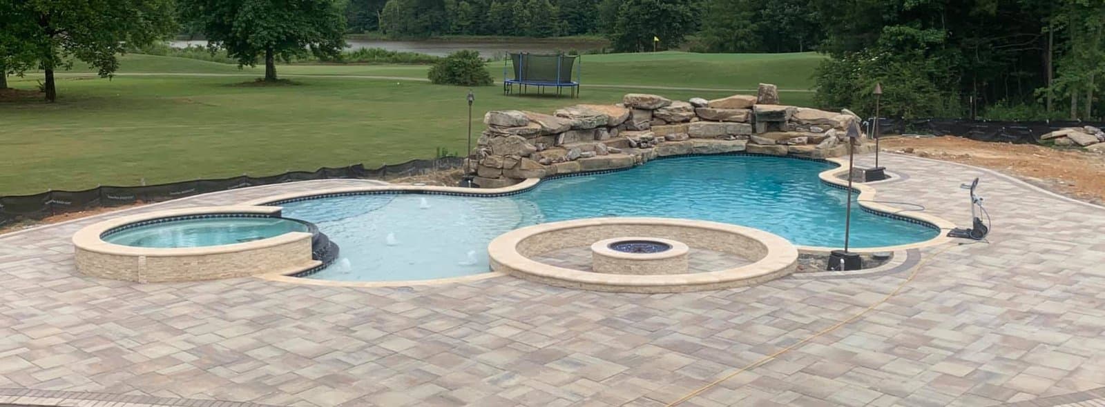 A large custom pool with spa and fire feature