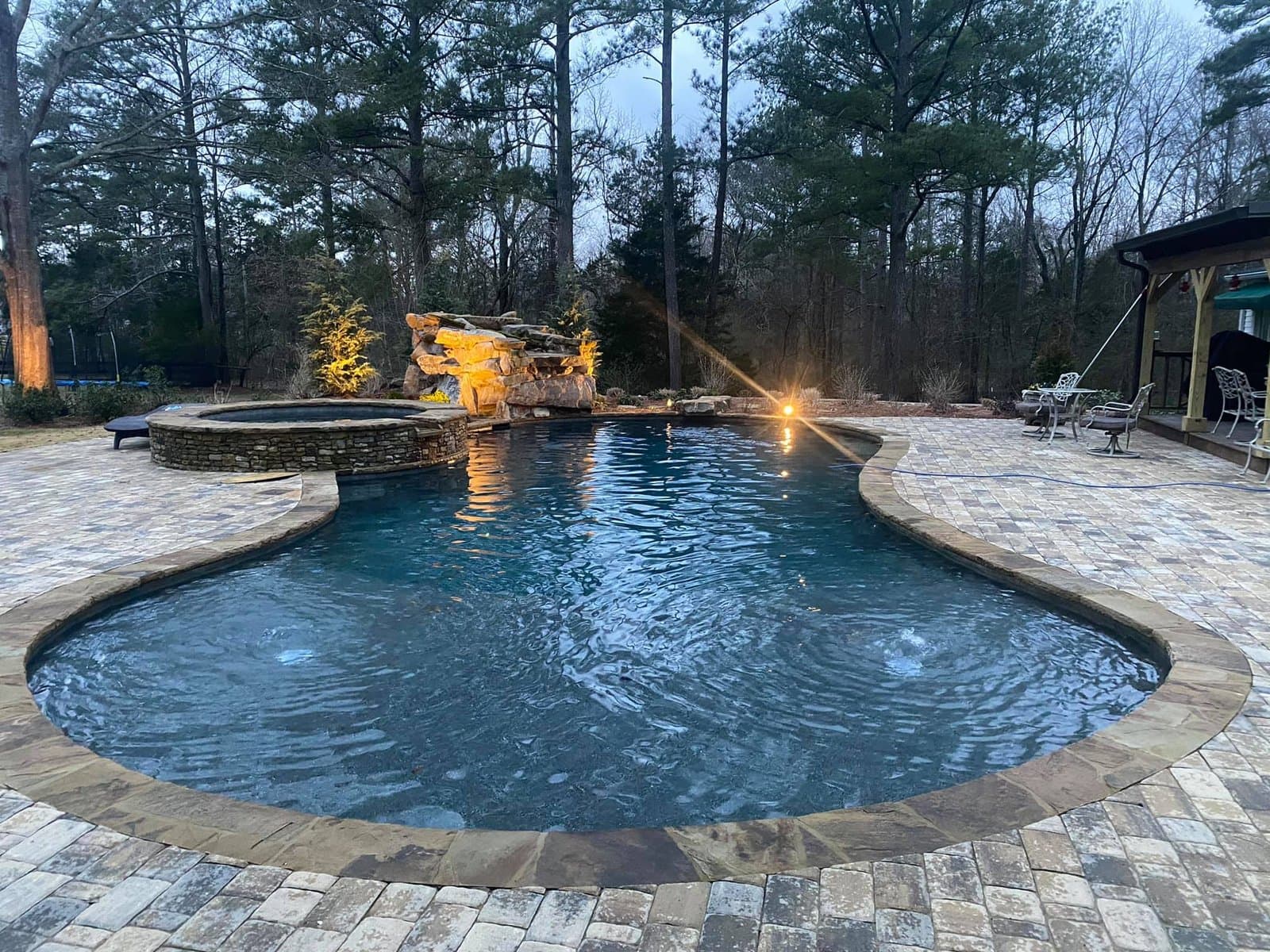 A custom gunite pool with rock waterfall and spa