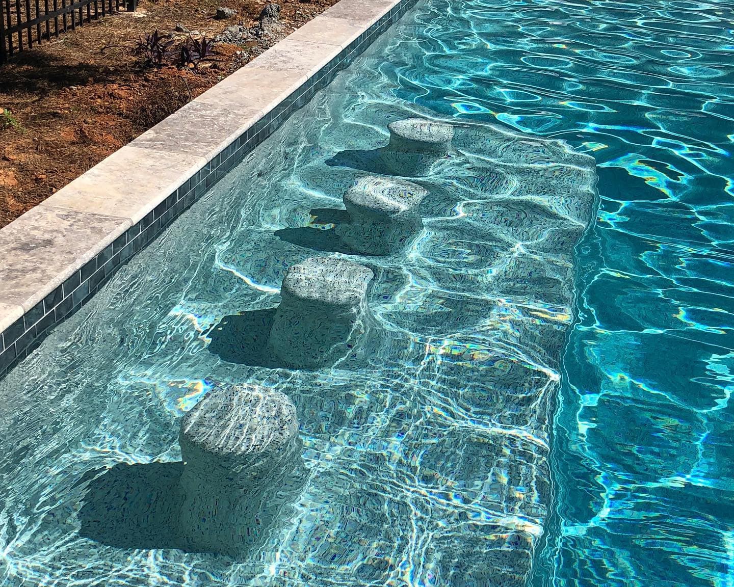 A renovated pool with a swim-up bar and new tile