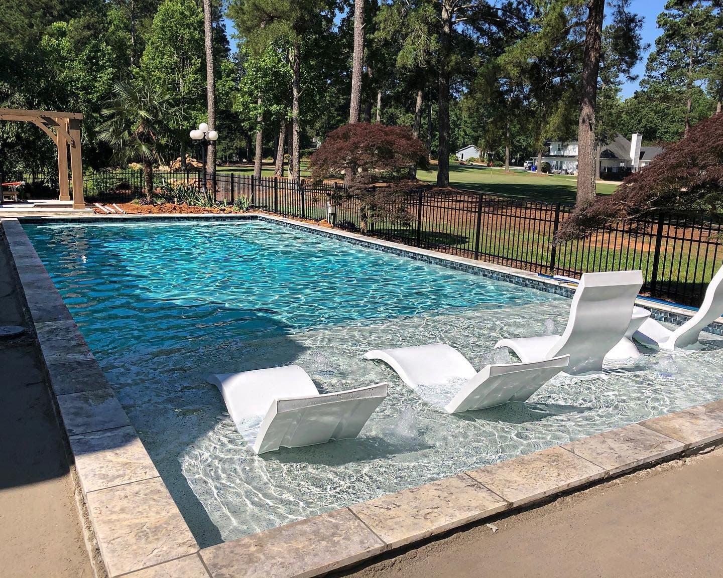 A sunny custom pool with in-water loungers